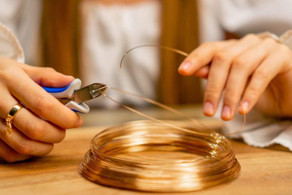 close-up-hands-of-a-young-girl-makes-jewelry-with-2024-01-19-00-35-01-utc-1-scaled-1-1024x683 راهنمای سفارش ساخت قطعات مسی سفارشی